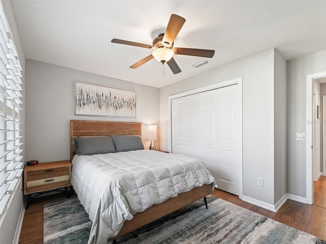 bedroom with a closet, dark hardwood / wood-style floors, and ceiling fan