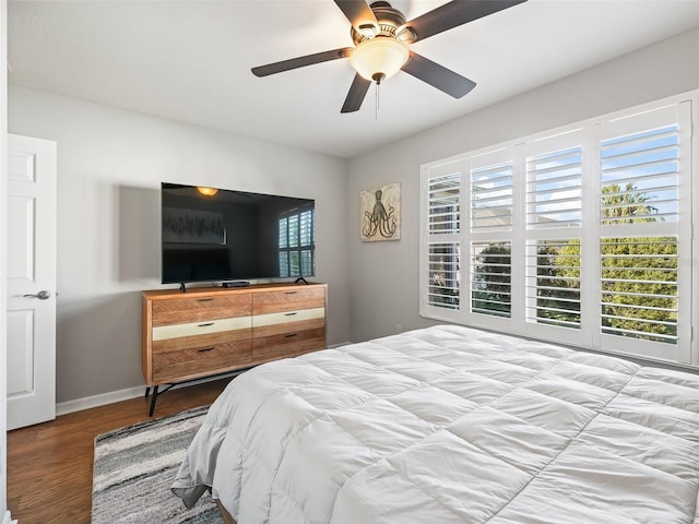 bedroom with baseboards, ceiling fan, and wood finished floors