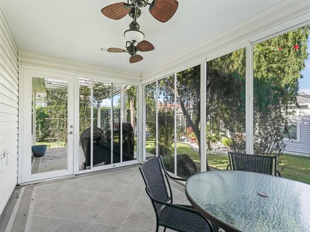 sunroom / solarium with ceiling fan and outdoor dining area