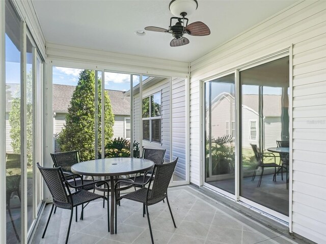 sunroom / solarium featuring a ceiling fan and outdoor dining area