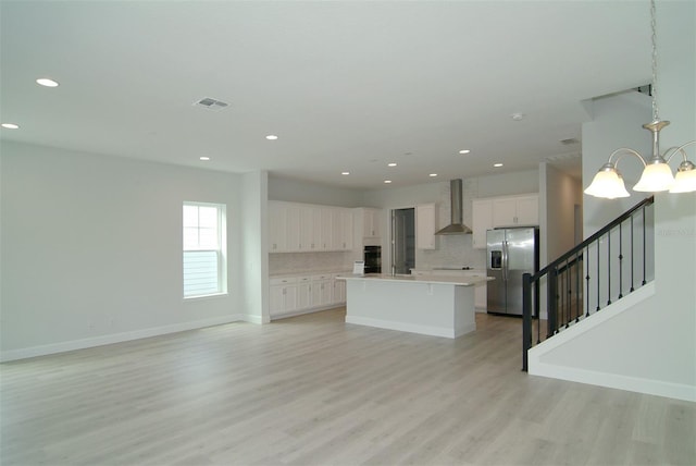 unfurnished living room with a notable chandelier and light wood-type flooring