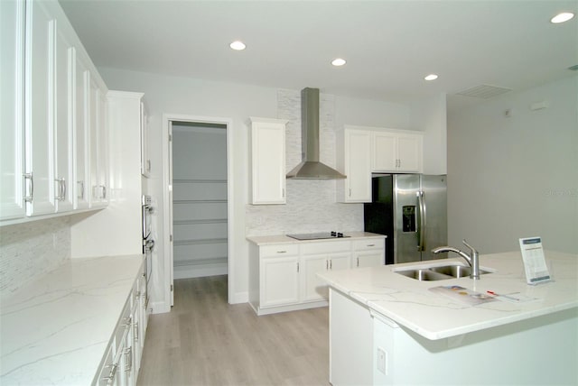 kitchen featuring sink, light hardwood / wood-style floors, wall chimney exhaust hood, white cabinets, and stainless steel fridge with ice dispenser