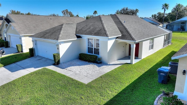 view of front of property featuring cooling unit, a front yard, and a garage