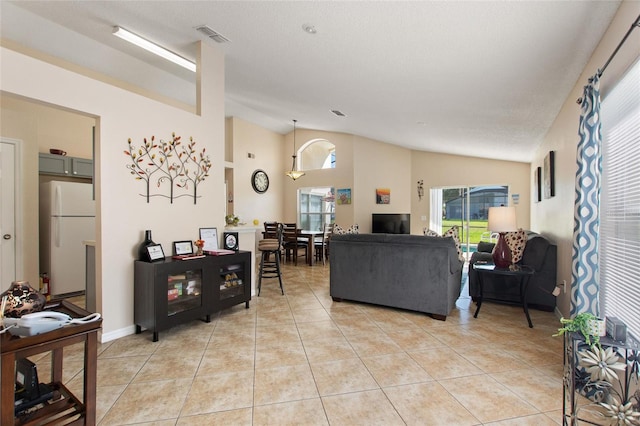 tiled living room with a textured ceiling and vaulted ceiling