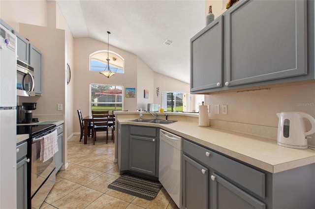 kitchen featuring gray cabinetry, stainless steel appliances, sink, and vaulted ceiling