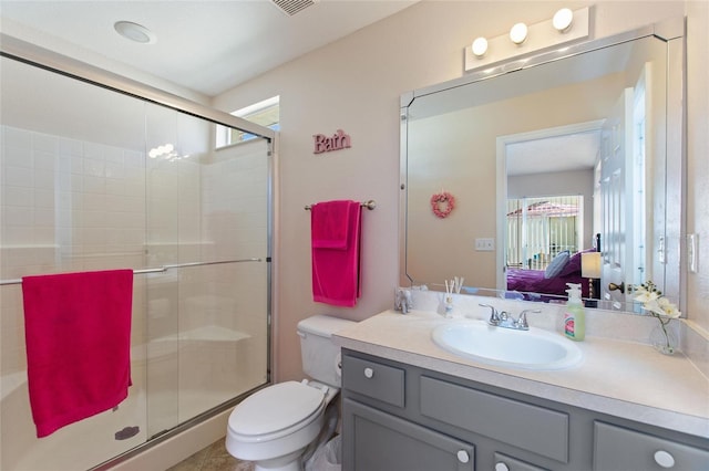 bathroom featuring vanity, toilet, and a shower with door