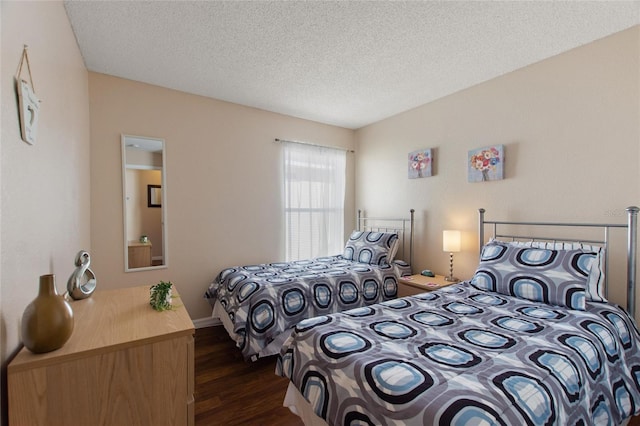 bedroom with dark wood-type flooring and a textured ceiling