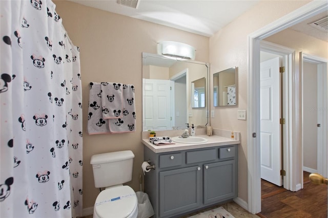 bathroom with toilet, hardwood / wood-style floors, and vanity