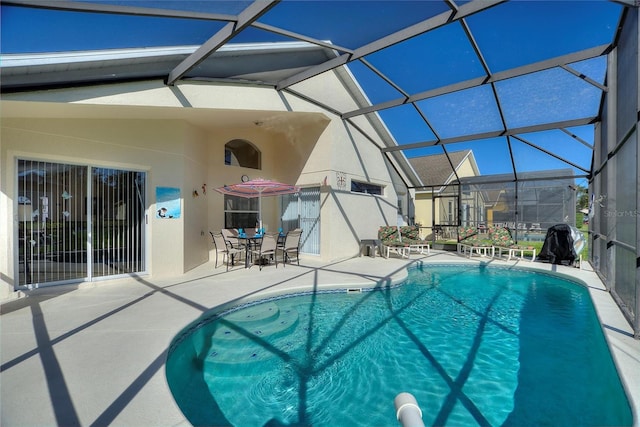 view of swimming pool featuring a patio and a lanai