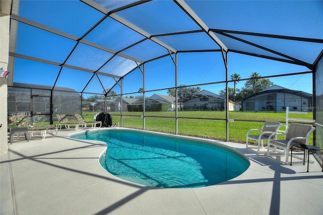 view of swimming pool with a patio, a lanai, and a lawn