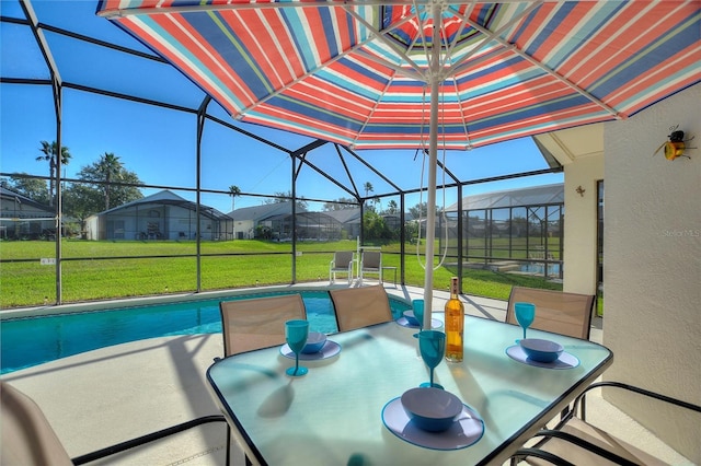 exterior space featuring a yard, a patio, and glass enclosure