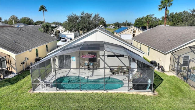 rear view of property featuring a patio, a lawn, and glass enclosure