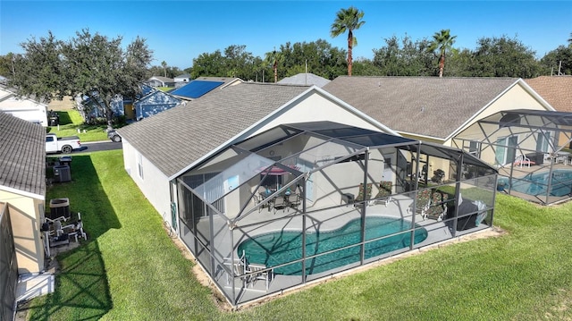 rear view of house featuring a patio area, a lanai, and a yard