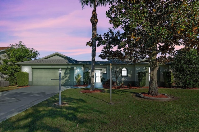 single story home featuring a lawn, central AC unit, and a garage