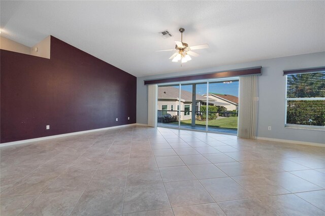 tiled empty room with ceiling fan and lofted ceiling