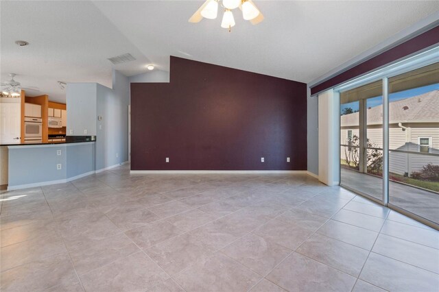 unfurnished living room with ceiling fan, lofted ceiling, and light tile patterned floors