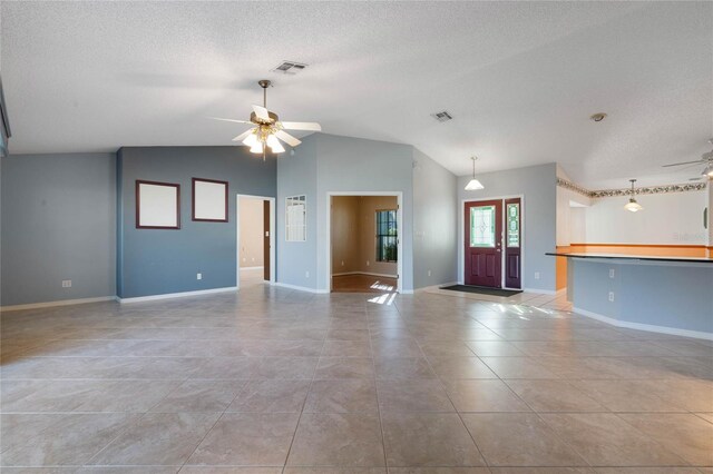 interior space featuring vaulted ceiling, a textured ceiling, and ceiling fan