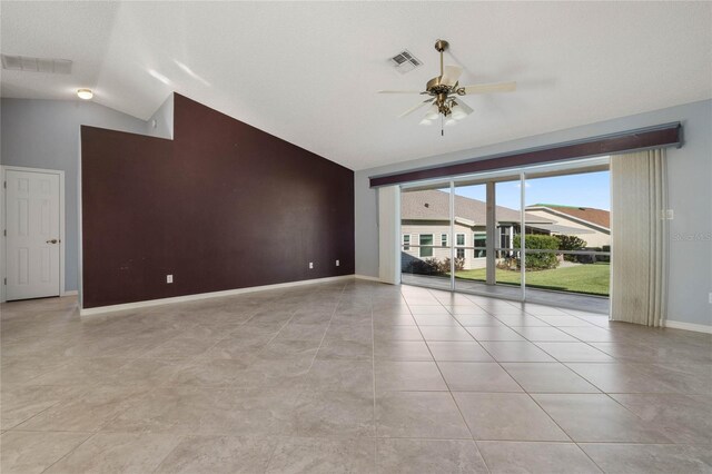 unfurnished room featuring ceiling fan, lofted ceiling, and light tile patterned floors