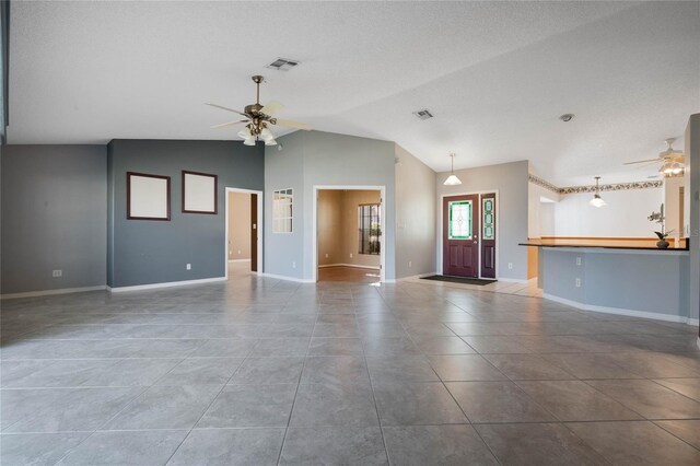 unfurnished living room with lofted ceiling, tile patterned flooring, and ceiling fan