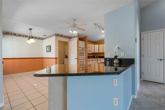 kitchen featuring pendant lighting, a textured ceiling, light tile patterned floors, and kitchen peninsula