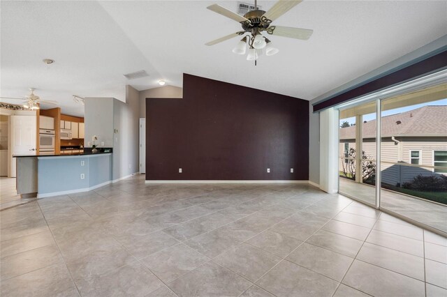 unfurnished living room with lofted ceiling, ceiling fan, and light tile patterned floors