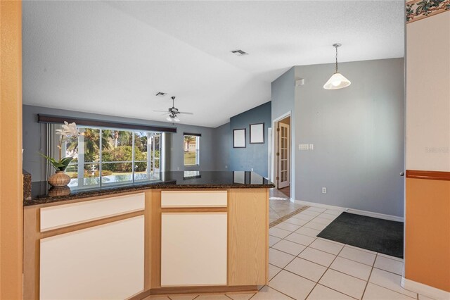 kitchen with hanging light fixtures, ceiling fan, light tile patterned floors, a textured ceiling, and vaulted ceiling