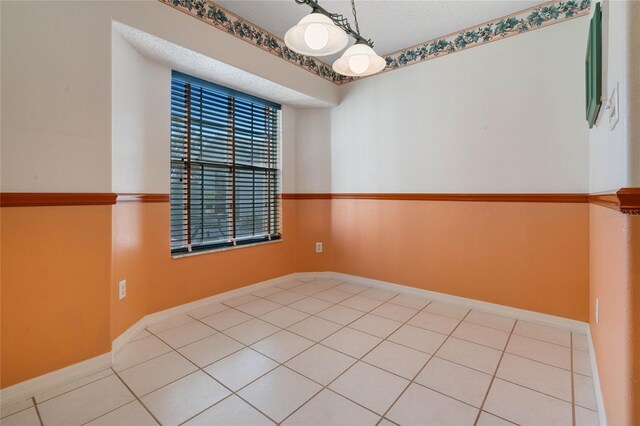 tiled spare room featuring a textured ceiling