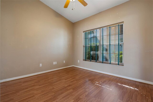 spare room with ceiling fan, vaulted ceiling, and hardwood / wood-style floors