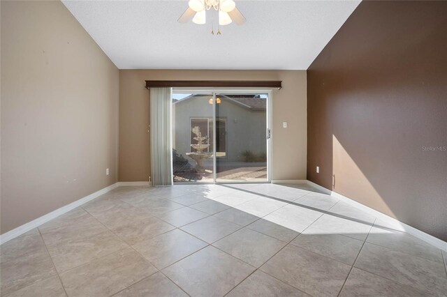 spare room featuring a textured ceiling, light tile patterned flooring, and ceiling fan