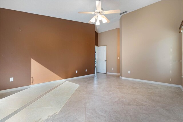 empty room featuring ceiling fan, lofted ceiling, and light tile patterned floors