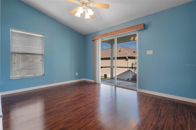 unfurnished room with a textured ceiling, vaulted ceiling, dark hardwood / wood-style floors, and ceiling fan