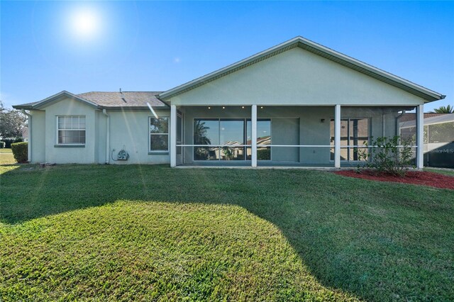 back of property featuring a yard and a sunroom