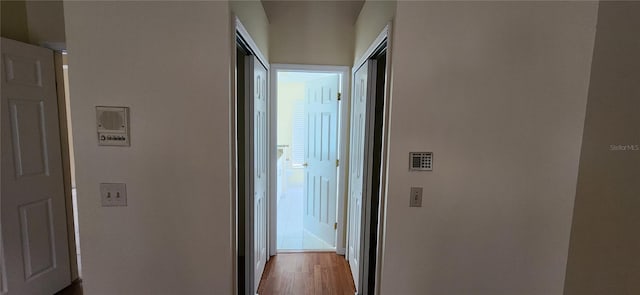 corridor with light hardwood / wood-style floors