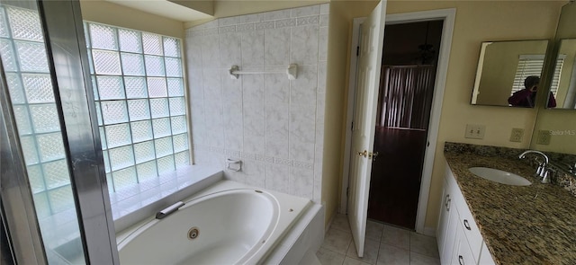 bathroom featuring tile walls, a bathtub, vanity, and tile patterned flooring