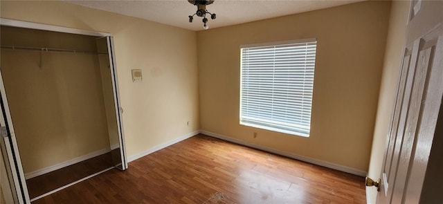 unfurnished bedroom featuring hardwood / wood-style floors and a closet