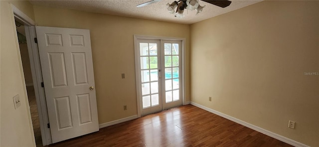 unfurnished room featuring wood-type flooring, a textured ceiling, ceiling fan, and french doors