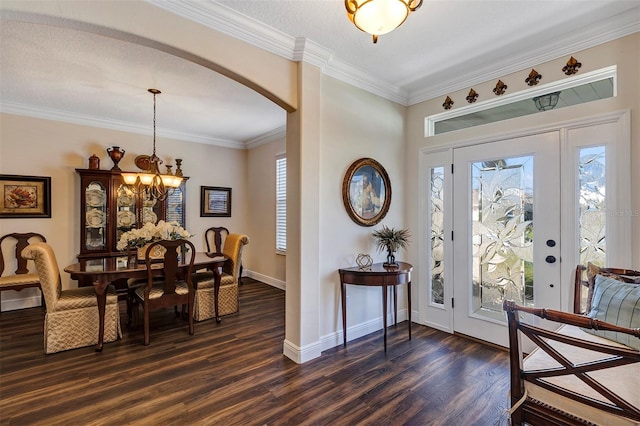 foyer entrance with dark hardwood / wood-style flooring, a chandelier, and crown molding