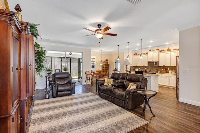 living room with ceiling fan, a textured ceiling, hardwood / wood-style flooring, and ornamental molding