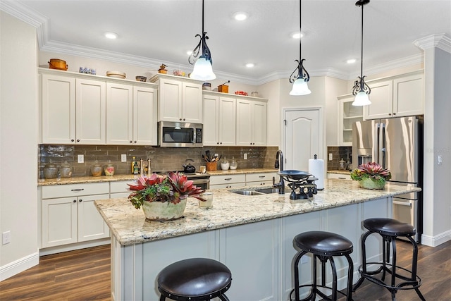 kitchen with decorative light fixtures, an island with sink, dark hardwood / wood-style floors, and stainless steel appliances