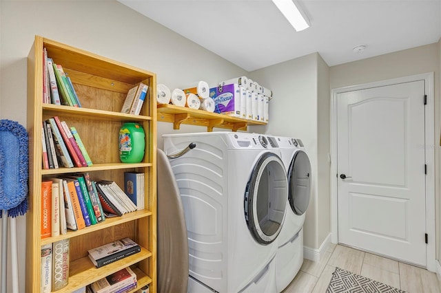 clothes washing area featuring washer and clothes dryer and light tile patterned floors