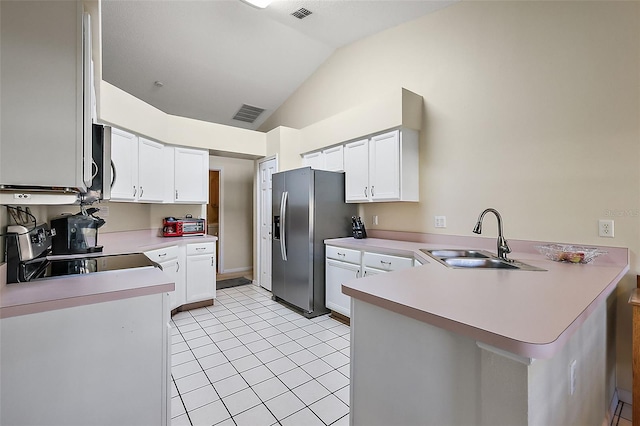 kitchen featuring lofted ceiling, sink, kitchen peninsula, and white cabinets