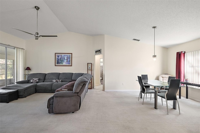 carpeted living room with ceiling fan, a textured ceiling, and lofted ceiling