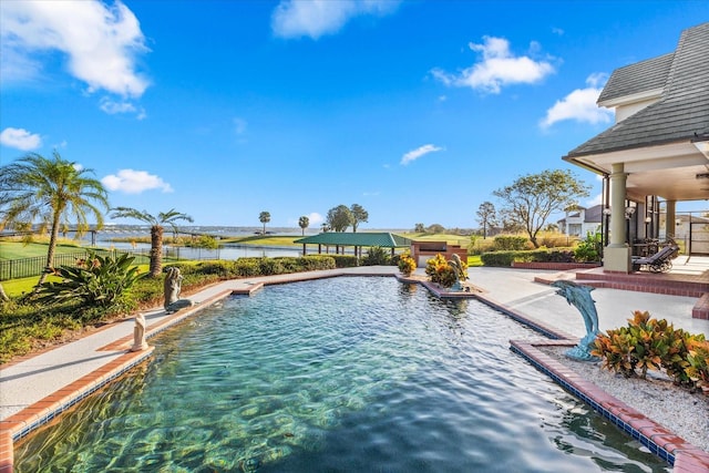 view of swimming pool with a patio, a water view, and ceiling fan