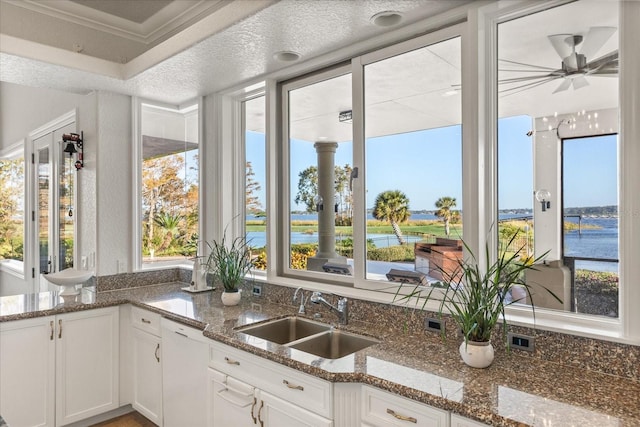 17601 Sawgrass Run, Tavares, FL 32778 - kitchen with a sink, dishwasher, a water view, white cabinetry, and a ceiling fan