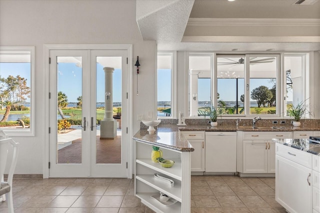 17601 Sawgrass Run, Tavares, FL 32778 - kitchen with french doors, white dishwasher, open shelves, white cabinets, and dark stone counters