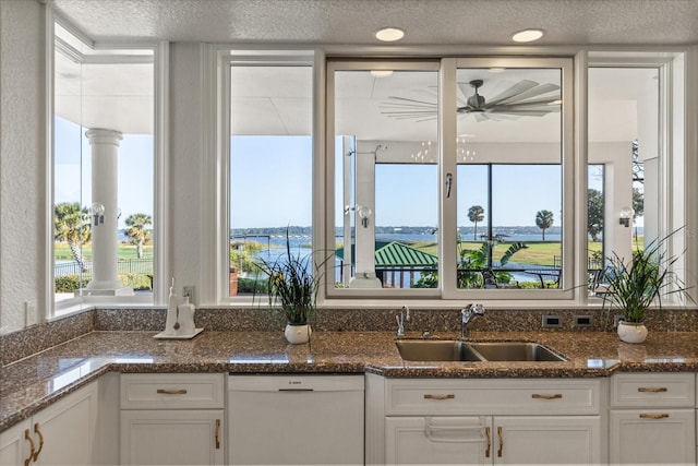 kitchen with white cabinetry, a water view, dishwasher, and sink