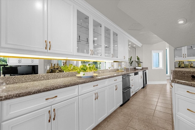 17601 Sawgrass Run, Tavares, FL 32778 - kitchen with stainless steel dishwasher, dark stone counters, white cabinetry, baseboards, and light tile patterned flooring