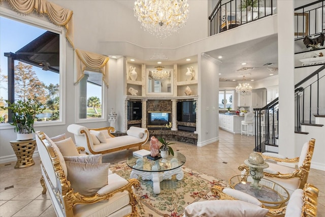 living room with a towering ceiling, ornamental molding, light tile patterned floors, and a high end fireplace