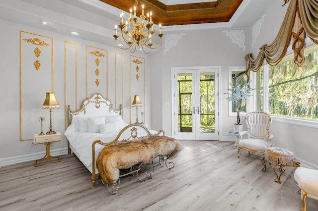 bedroom featuring an inviting chandelier, french doors, hardwood / wood-style floors, and access to exterior