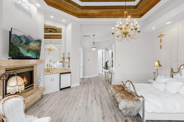 bedroom with light wood-type flooring and a raised ceiling